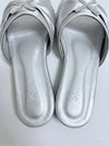 A pair of metallic silver slide sandals with a knotted bow detail on the strap embellished with rhinestones, shown from a top-down view on a light gray background.